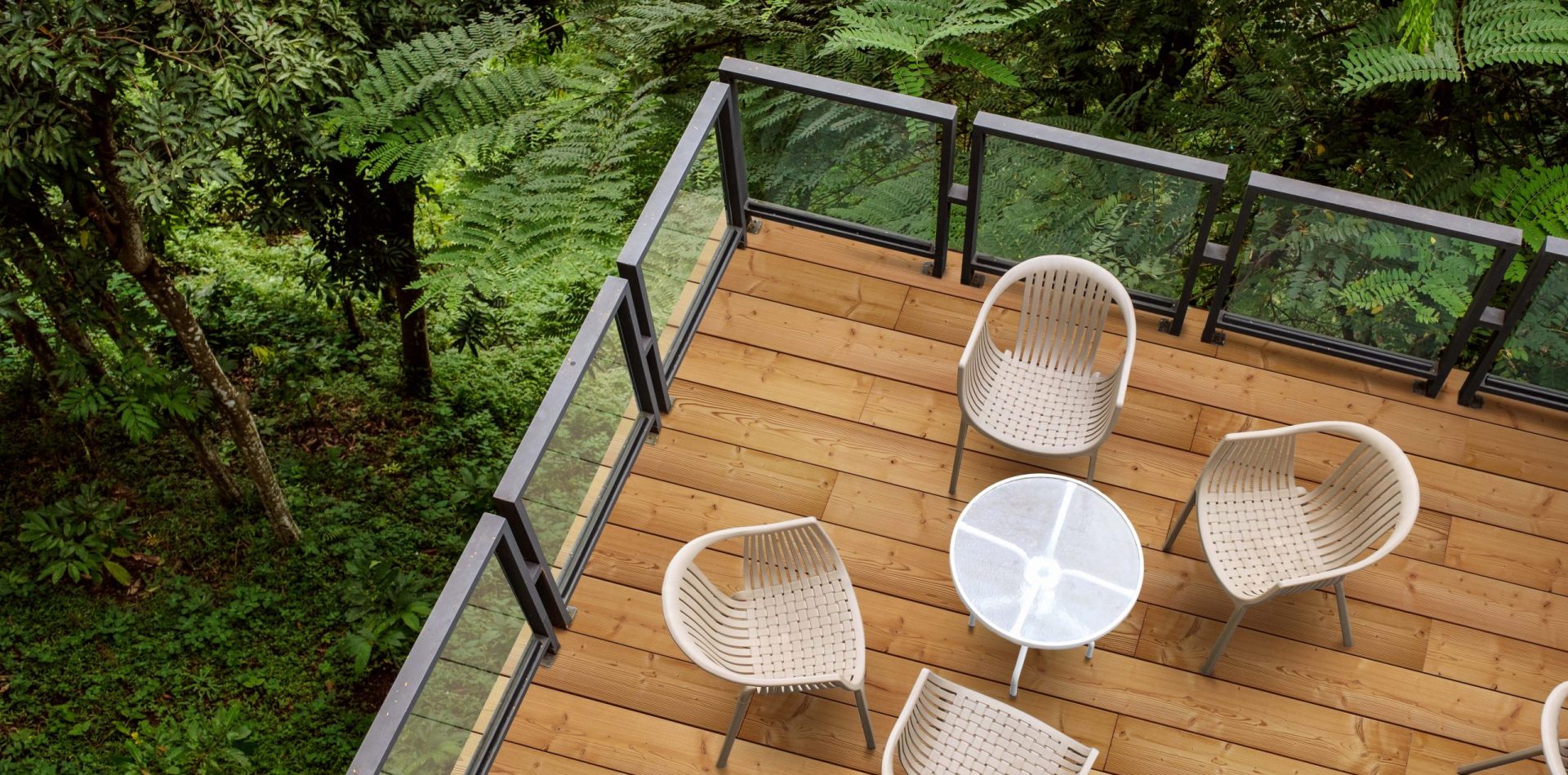 Wooden chairs with glass table on patio in tropical garden